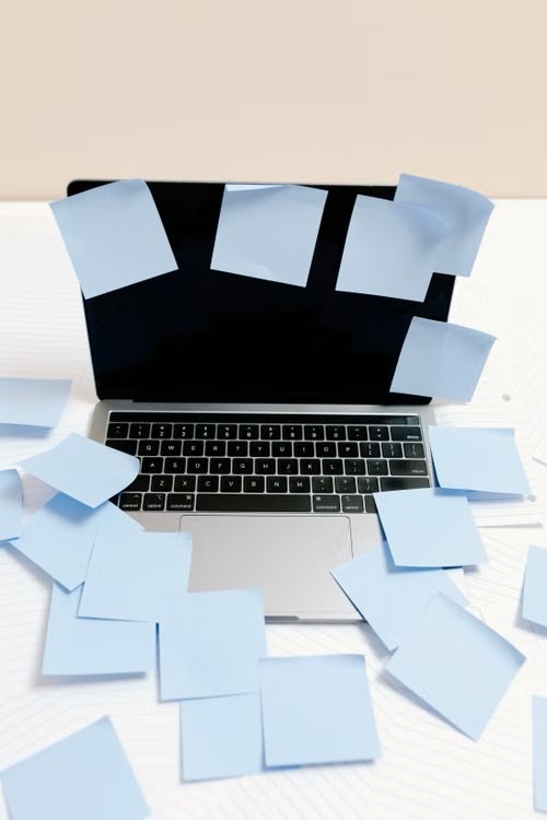 Ordinateur portable recouvert de post-it, planning improvisé